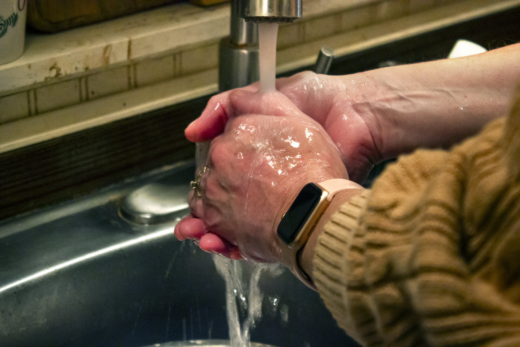 Picture of hands being washed in cold water.
